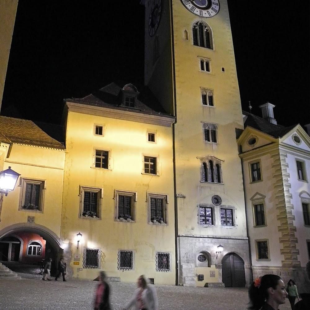 A tall clock tower at night in a European town.